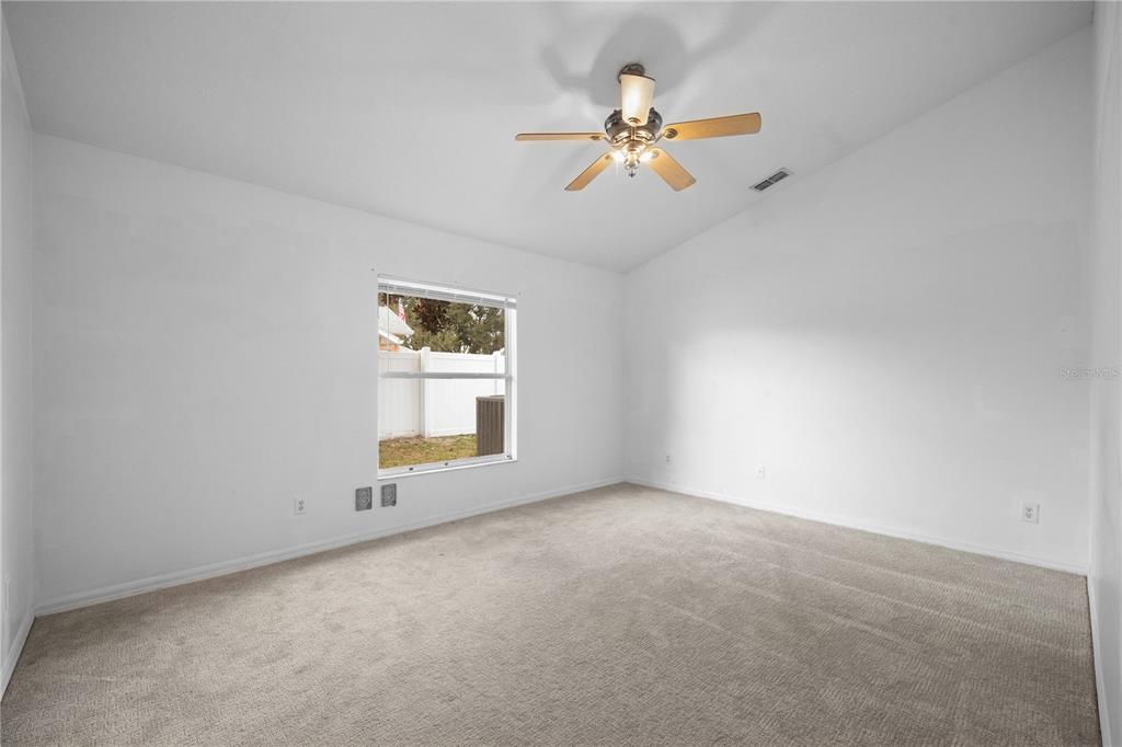 11748 Constance Way Clermont, FL 34711 - Photo 17 of 45 an empty room with windows and chandelier fan