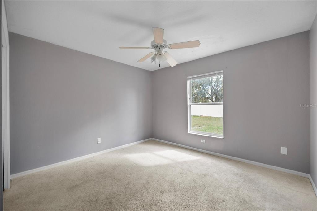 11748 Constance Way Clermont, FL 34711 - Photo 20 of 45 an empty room with a window and a fan