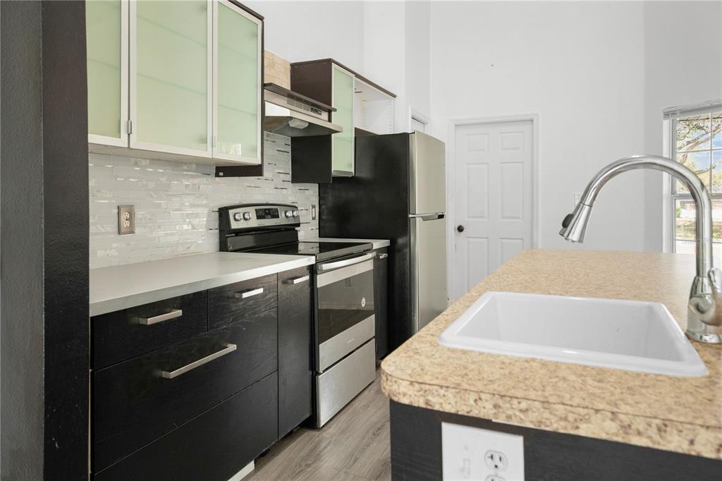 11748 Constance Way Clermont, FL 34711 - Photo 7 of 45 a kitchen with stainless steel appliances granite countertop a sink a stove and a refrigerator