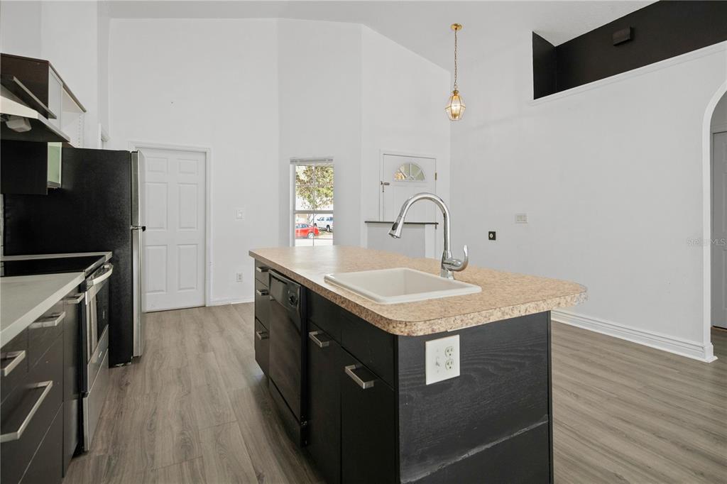 11748 Constance Way Clermont, FL 34711 - Photo 8 of 45 a kitchen with a sink a microwave a refrigerator and wooden floor