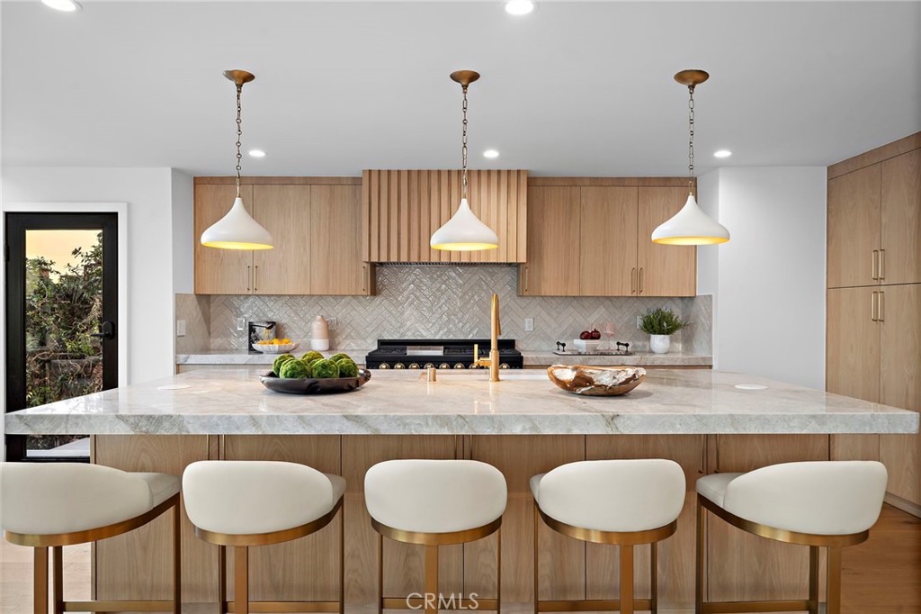 16471 Barnstable Circle Huntington Beach, CA 92649 - Photo 13 of 57 a kitchen with stainless steel appliances granite countertop a table chairs stove and sink