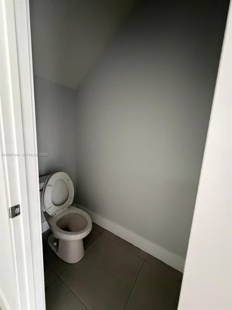 381 East 50th Street, Unit 6 Hialeah, FL 33013 - Photo 14 of 37 a bathroom with a granite countertop toilet and a sink