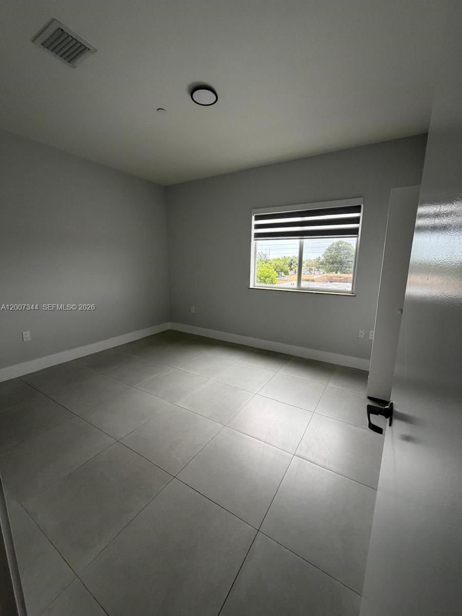 381 East 50th Street, Unit 6 Hialeah, FL 33013 - Photo 22 of 37 en empty room with windows and ceiling fan