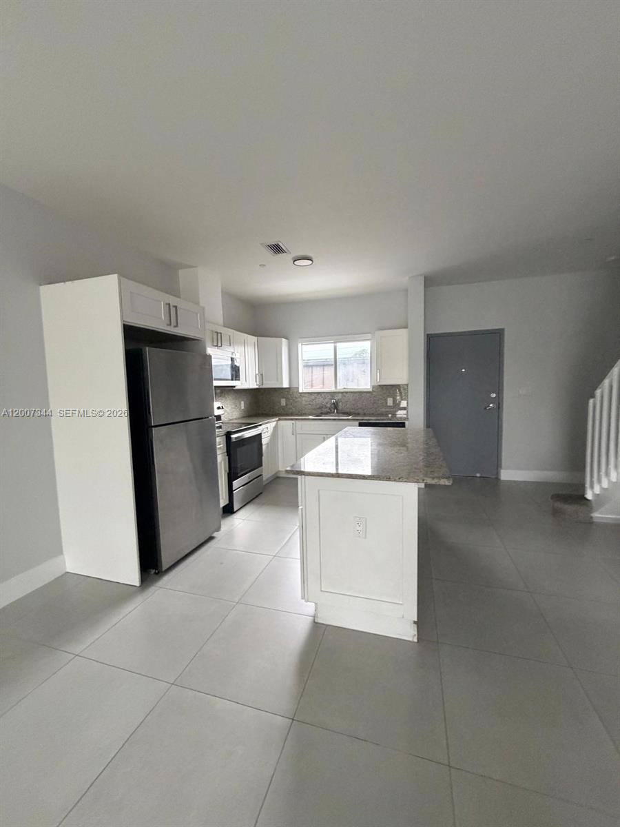 381 East 50th Street, Unit 6 Hialeah, FL 33013 - Photo 3 of 37 a kitchen with a refrigerator and a stove top oven