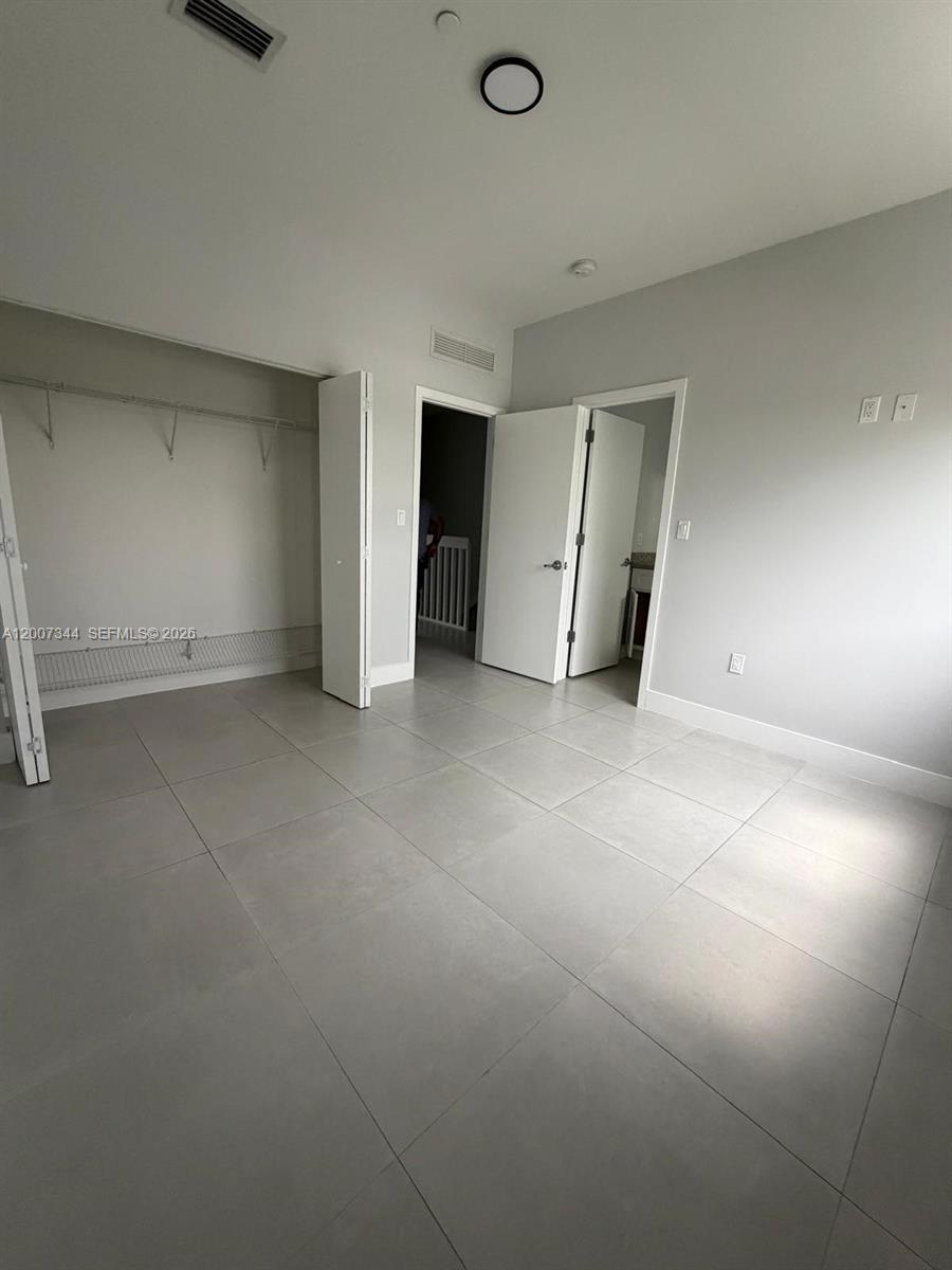 381 East 50th Street, Unit 6 Hialeah, FL 33013 - Photo 31 of 37 an empty room with closet and windows