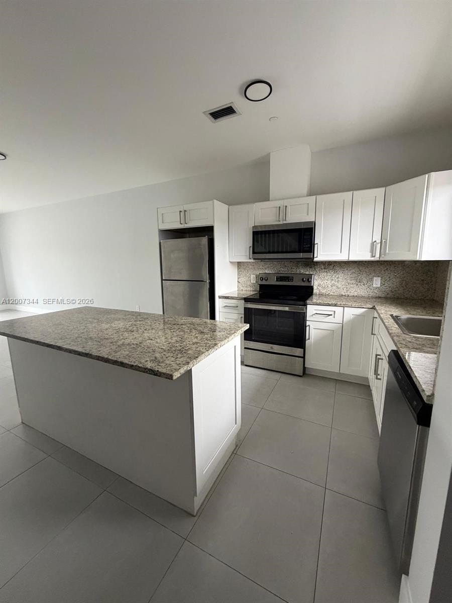 381 East 50th Street, Unit 6 Hialeah, FL 33013 - Photo 4 of 37 a kitchen with granite countertop a stove and a sink