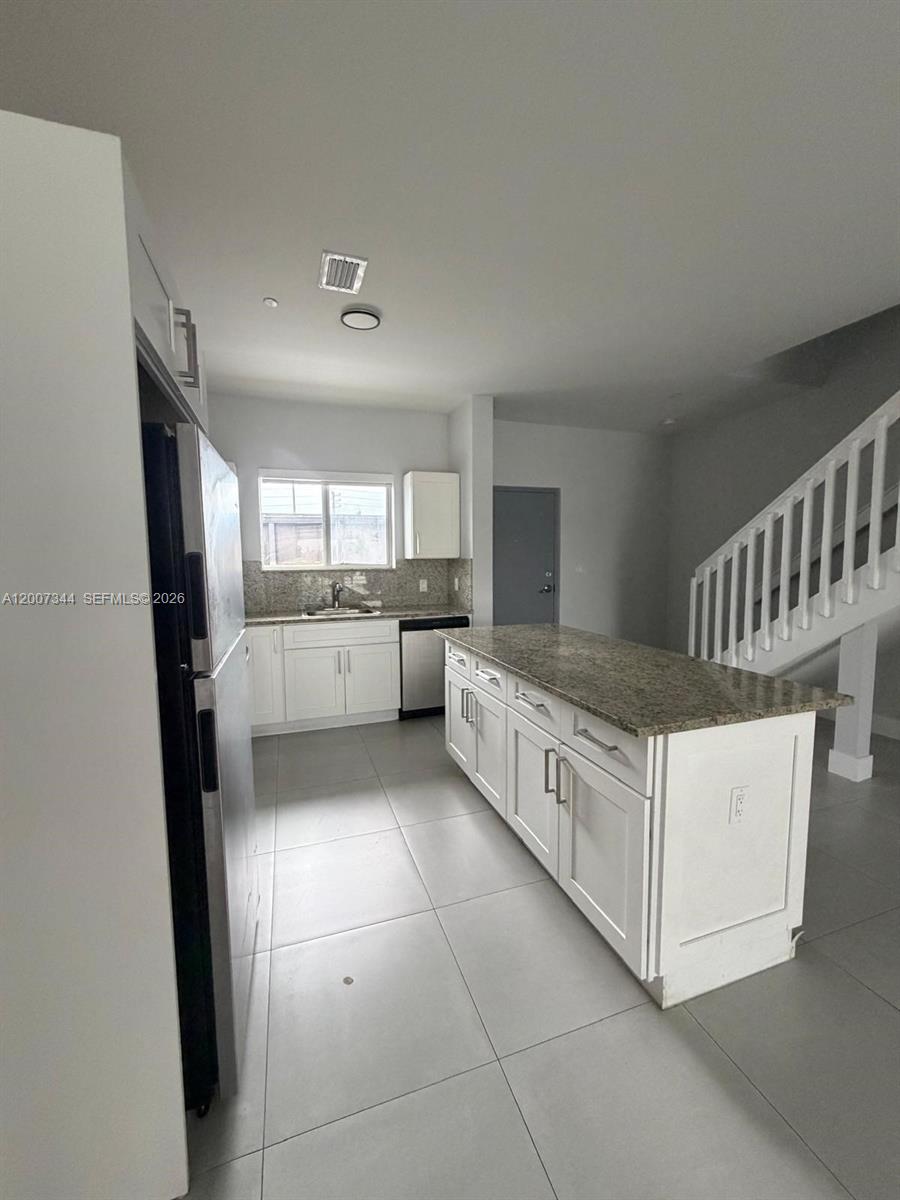 381 East 50th Street, Unit 6 Hialeah, FL 33013 - Photo 5 of 37 a large white kitchen with a stove a refrigerator a sink a microwave and cabinets
