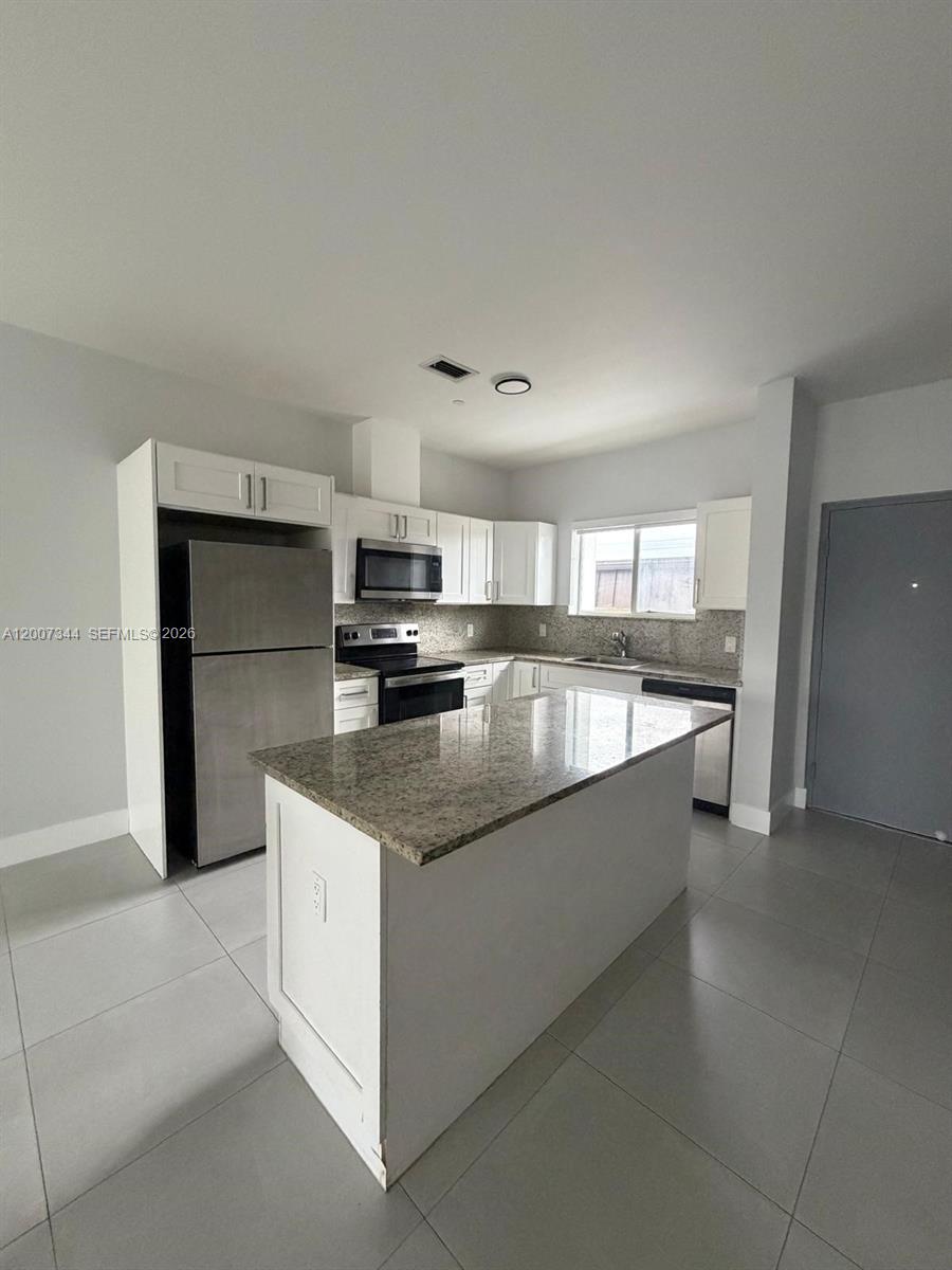 381 East 50th Street, Unit 6 Hialeah, FL 33013 - Photo 6 of 37 a large kitchen with granite countertop a large counter top appliances and cabinets