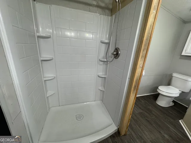 an empty room with chandelier fan and windows