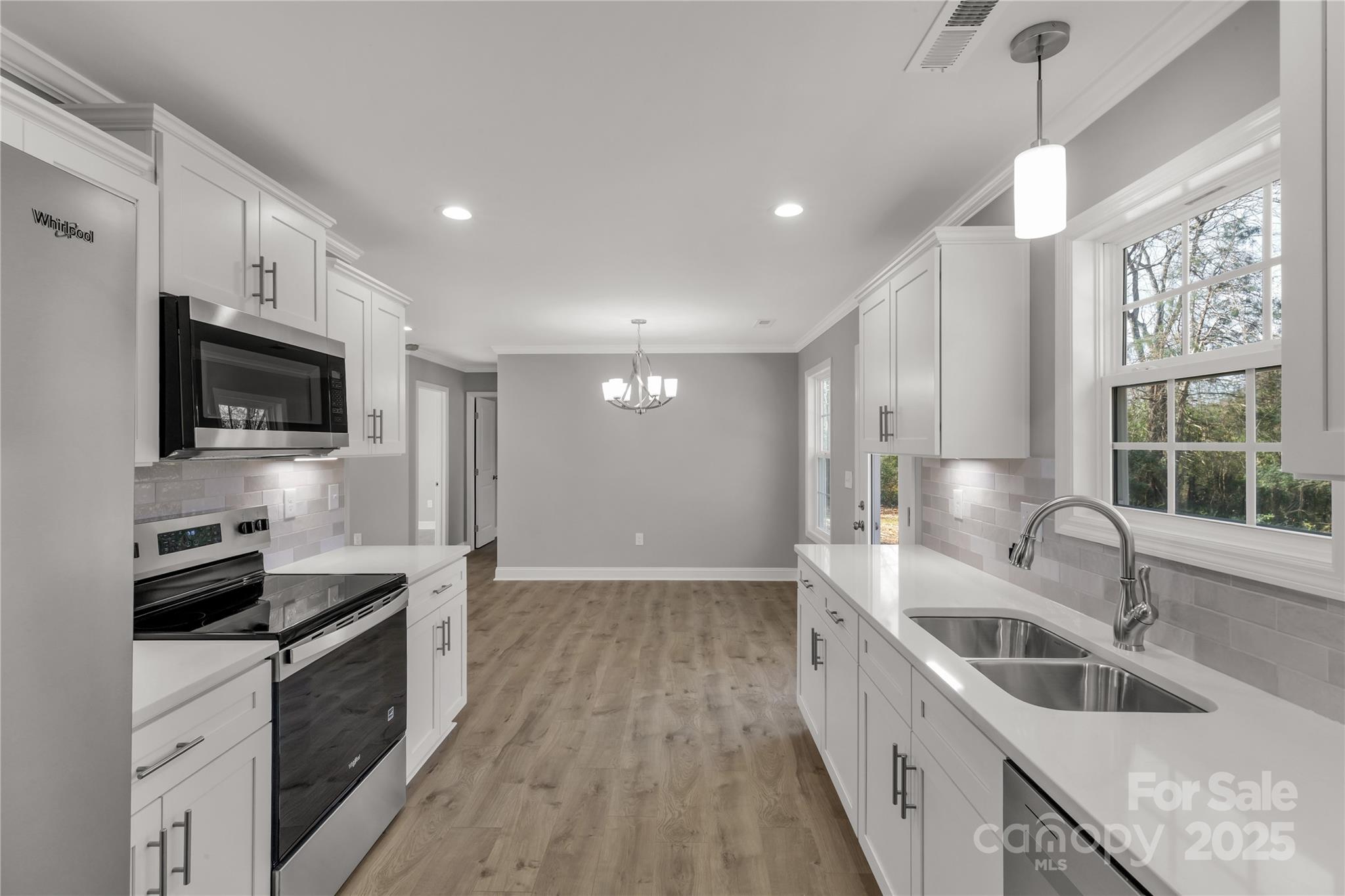 a kitchen with granite countertop a sink and steel appliances
