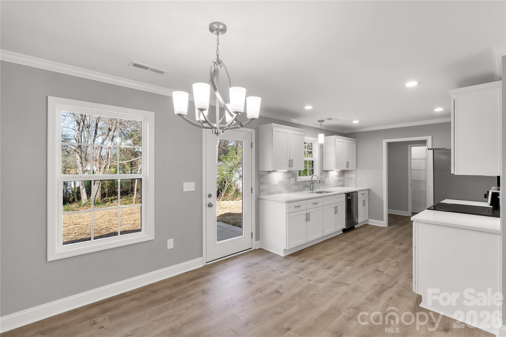 2166 Reeves Road Lancaster, SC 29720 - Photo 10 of 37 a view of a kitchen with stainless steel appliances granite countertop a refrigerator a stove a sink dishwasher a dining table and chairs with wooden floor