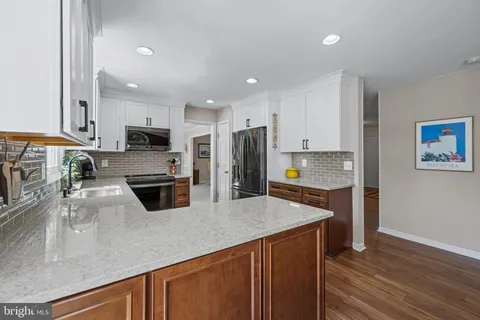 a kitchen with stainless steel appliances granite countertop a sink a stove top oven a counter space and cabinets