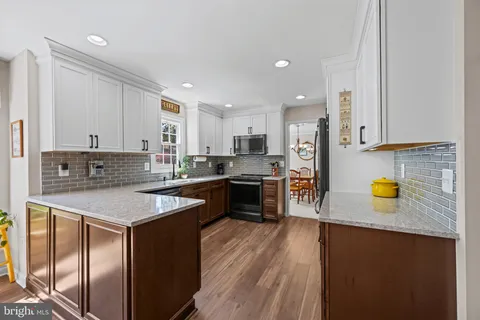 a kitchen with a refrigerator a sink dishwasher and a stove with wooden floor
