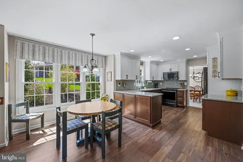 a kitchen with kitchen island a dining table chairs and wooden floor