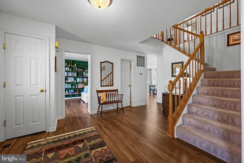 a living room with wooden floor and stairs