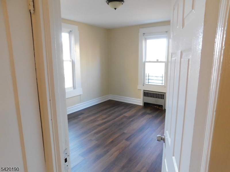 282 Renner Avenue, Unit 1 Newark, NJ 07112 - Photo 17 of 19 a view of an empty room with wooden floor and a window