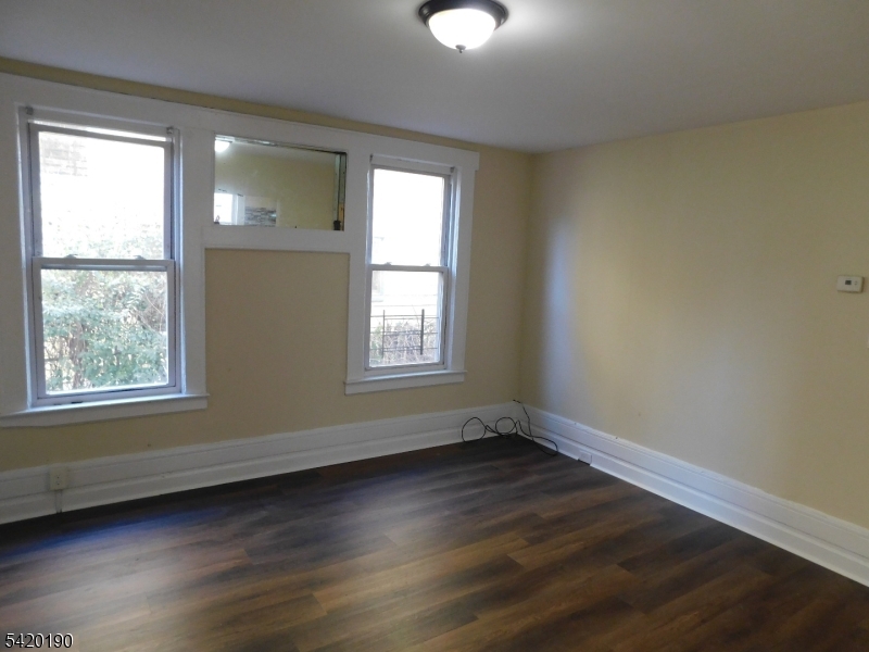 282 Renner Avenue, Unit 1 Newark, NJ 07112 - Photo 5 of 19 a view of an empty room with wooden floor and a window