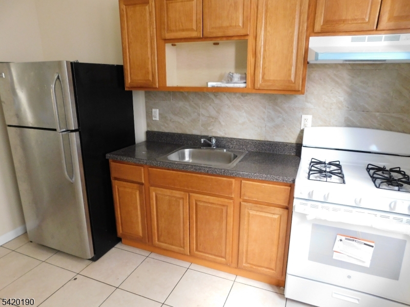 282 Renner Avenue, Unit 1 Newark, NJ 07112 - Photo 9 of 19 a kitchen with stainless steel appliances granite countertop a refrigerator and a stove