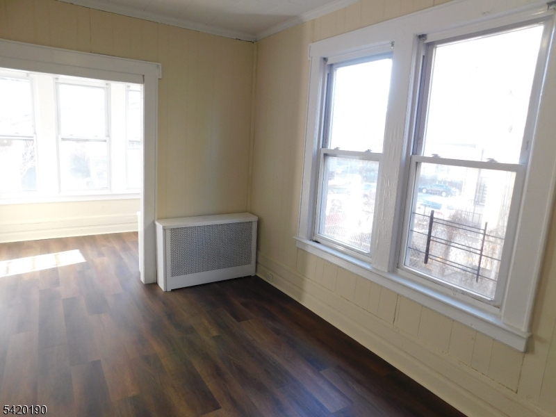 282 Renner Avenue, Unit 1 Newark, NJ 07112 - Photo 10 of 19 a view of an empty room with wooden floor and a window
