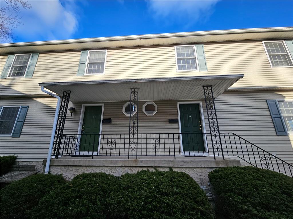 a front view of a house with plants