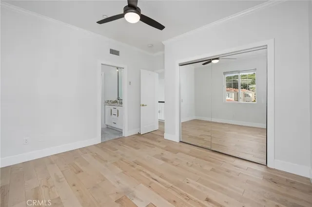 an empty room with a window and ceiling fan