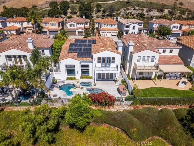 an aerial view of residential houses with outdoor space and trees