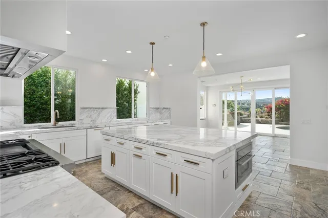 a kitchen with granite countertop a sink and white cabinets