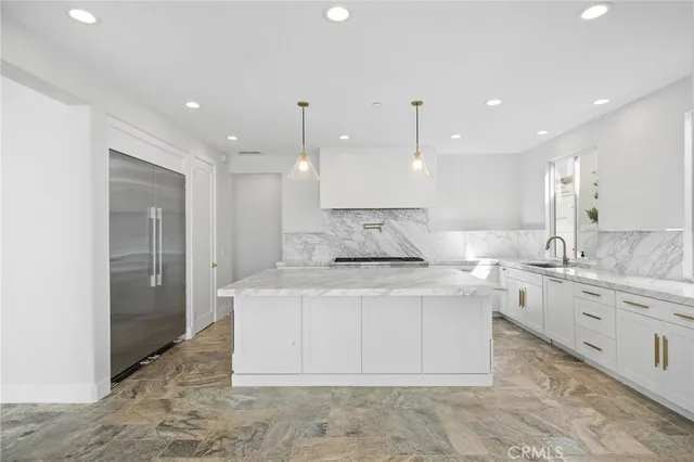 a view of a kitchen with kitchen island a sink stainless steel appliances and a counter top
