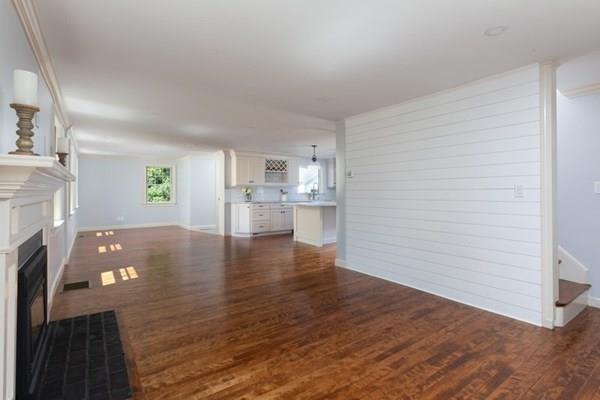 25 Magnolia Road Milton, MA 02186 - Photo 4 of 28 a view of empty room with wooden floor and a fireplace