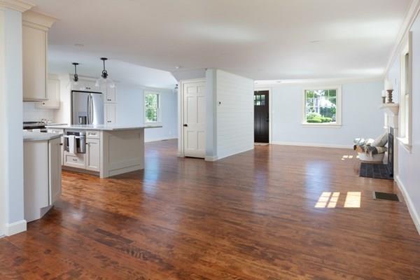 25 Magnolia Road Milton, MA 02186 - Photo 6 of 28 a view of a kitchen with kitchen island a sink wooden floor and a refrigerator