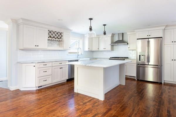 25 Magnolia Road Milton, MA 02186 - Photo 8 of 28 a kitchen with white cabinets and stainless steel appliances