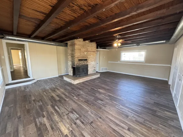 a view of empty room with wooden floor and fireplace