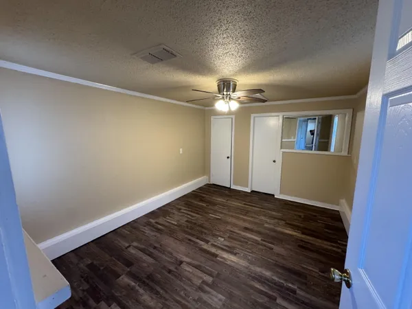 a view of an empty room with a chandelier fan