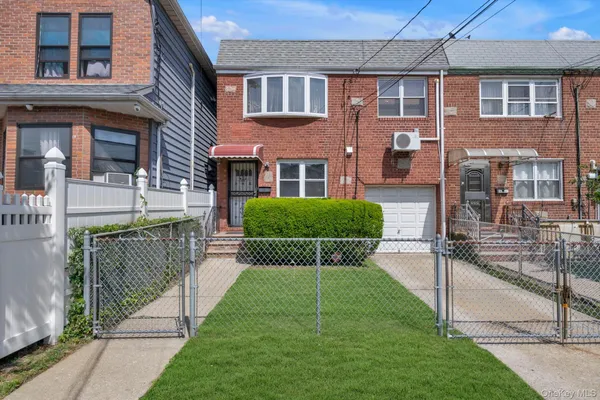 a view of a brick house with a yard and plants