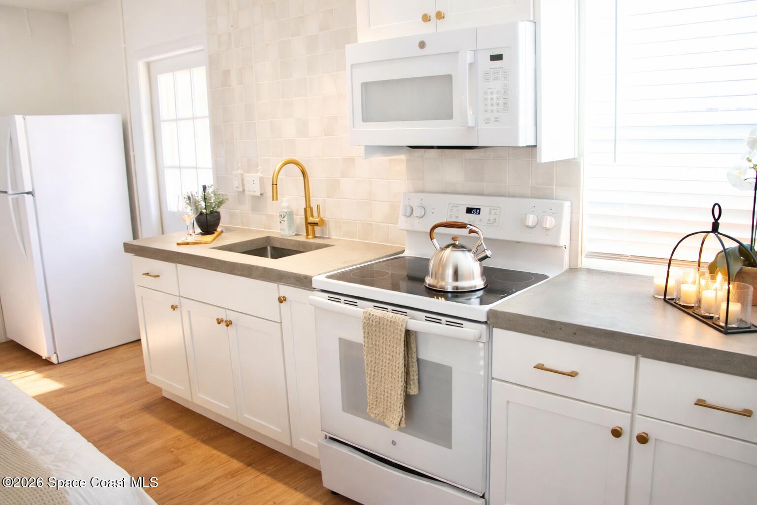 804 Oak Street Melbourne Beach, FL 32951 - Photo 38 of 51 a kitchen with sink and white cabinets