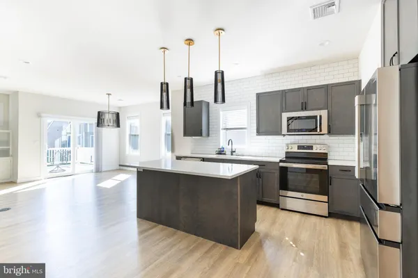 a kitchen with stainless steel appliances kitchen island granite countertop a sink and a stove