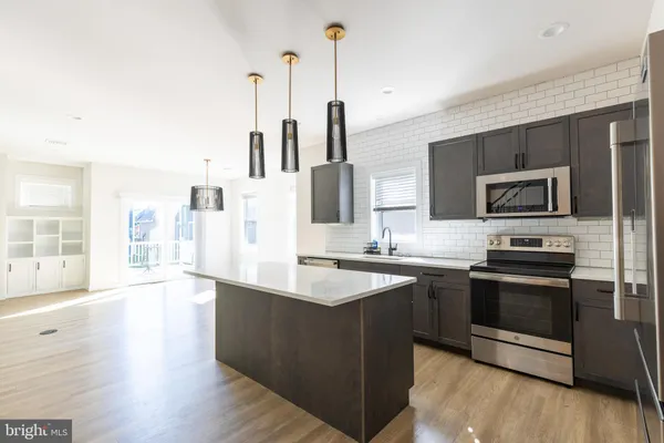 a kitchen with stainless steel appliances a sink and a refrigerator
