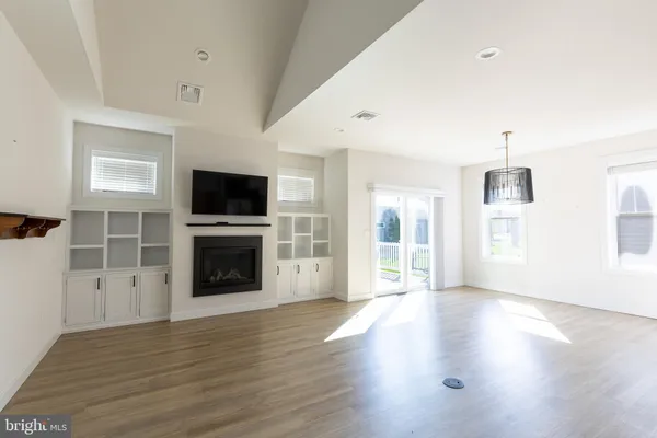 a view of empty room with a kitchen and microwave