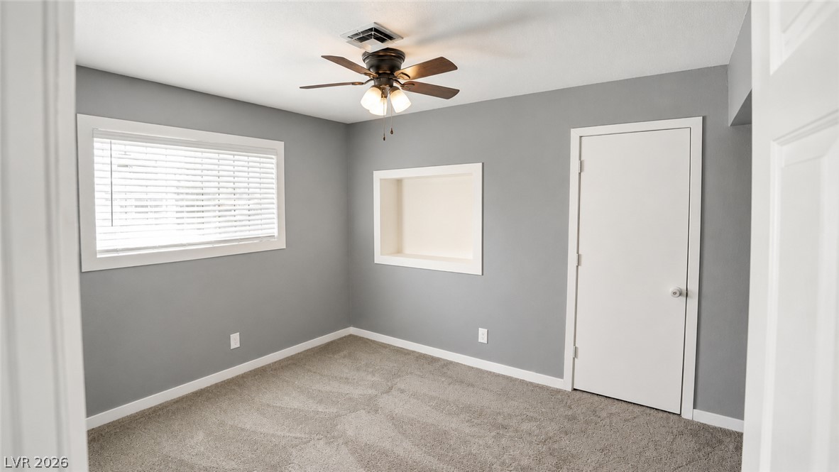 2870 South Sandhill Road Las Vegas, NV 89121 - Photo 34 of 64 A well-lit bedroom with plush carpet and a ceiling fan offers comfortable living.