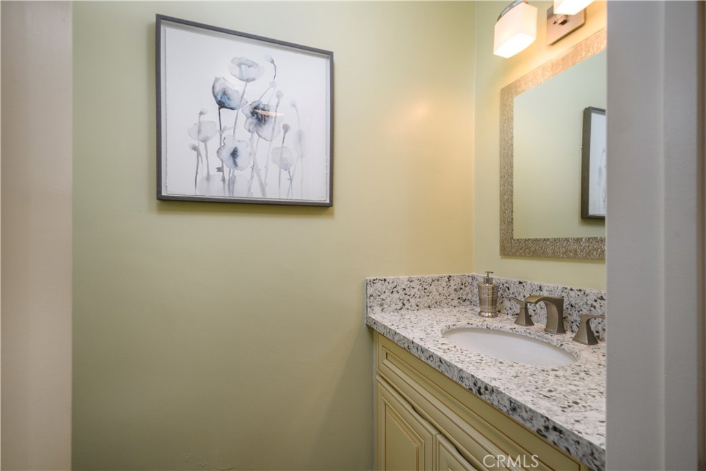 452 West Winnie Way Arcadia, CA 91007 - Photo 22 of 25 a bathroom with a granite countertop sink a mirror and a picture on the wall