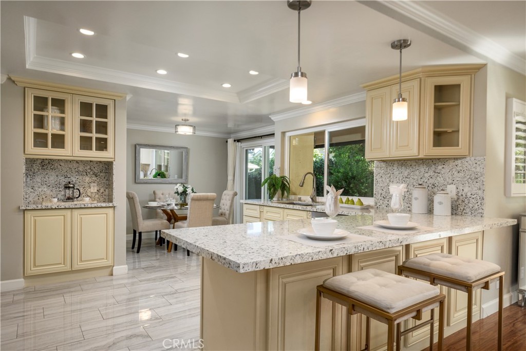 452 West Winnie Way Arcadia, CA 91007 - Photo 6 of 25 a kitchen with a stove a sink a kitchen island with chairs and wooden cabinets