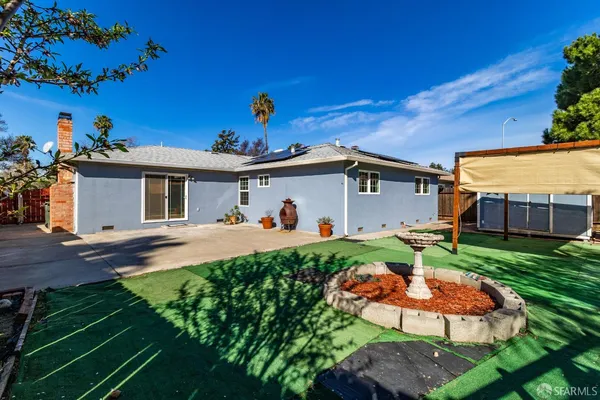 a view of a house with backyard and sitting area