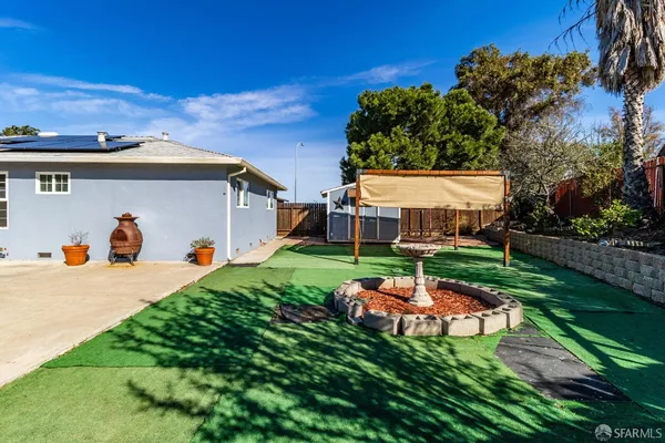 a backyard of a house with table and chairs