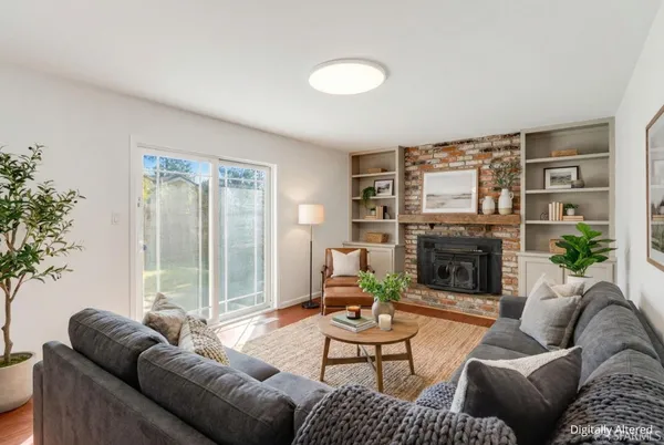 a living room with furniture a fireplace and a potted plant