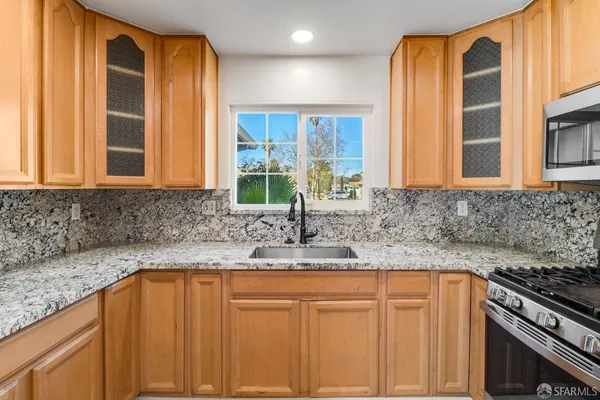 a kitchen with granite countertop a sink and a window