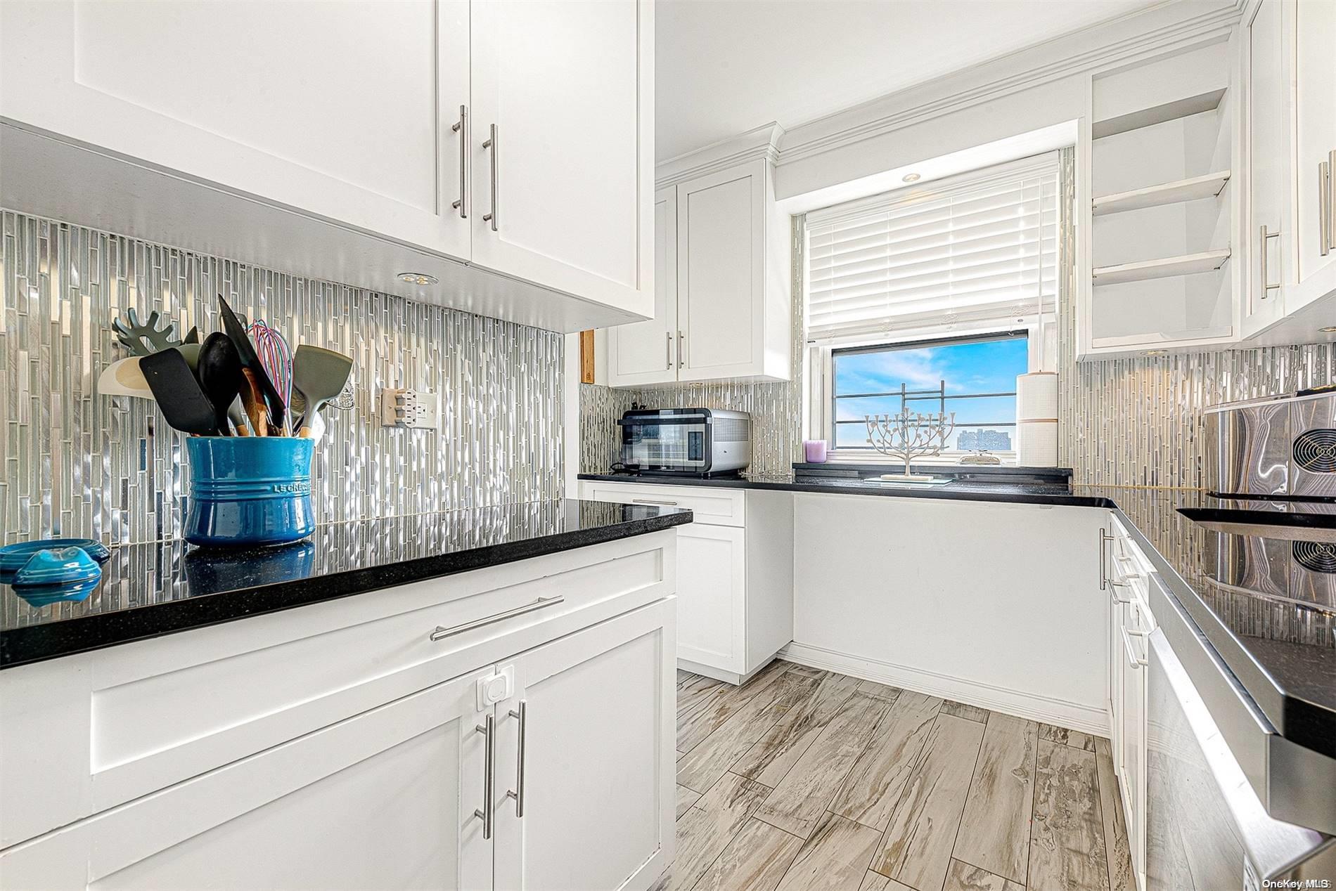 110-11 Queens Boulevard, Unit 20K Queens, NY 11375 - Photo 18 of 35 a kitchen with granite countertop white cabinets and white appliances