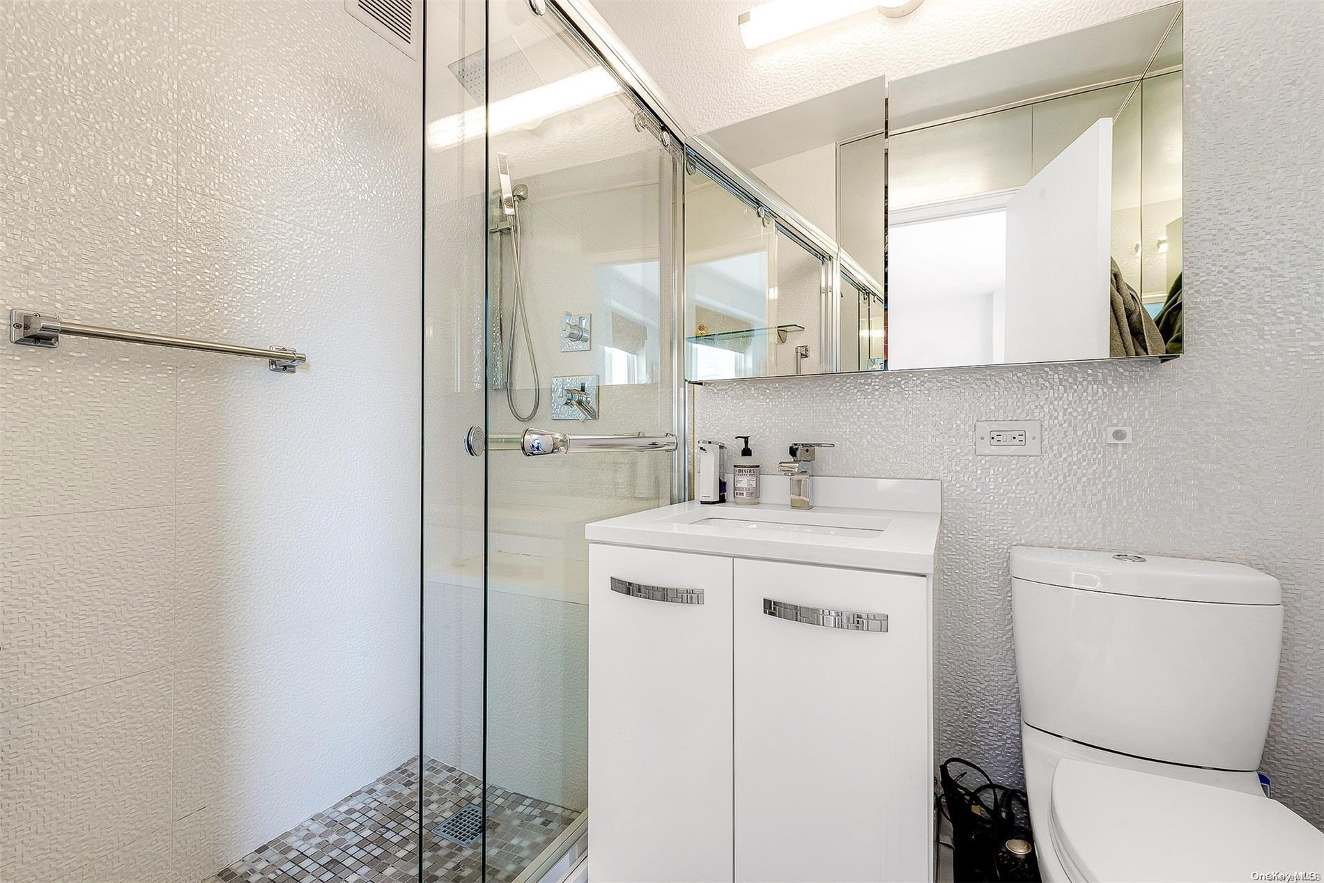 110-11 Queens Boulevard, Unit 20K Queens, NY 11375 - Photo 28 of 35 a bathroom with a sink a toilet and a mirror