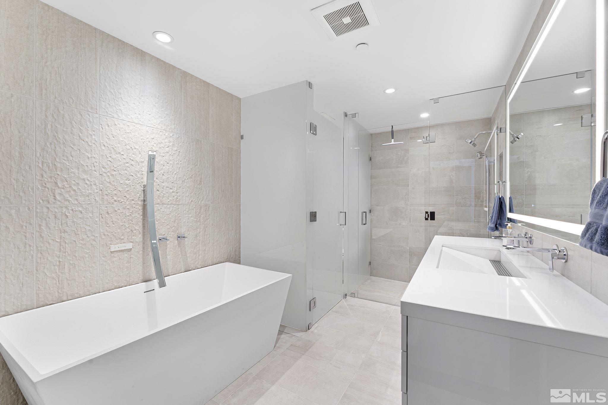 9 Beach Club Drive, Unit 111 Stateline, NV 89449 - Photo 21 of 40 a spacious bathroom with a tub sink shower and mirror