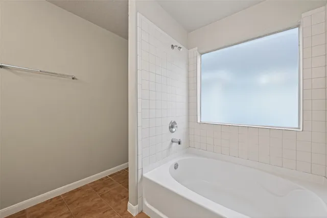 a bathroom with a tub sink and mirror