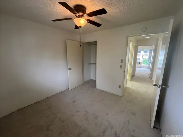 an empty room with fan and entrance
